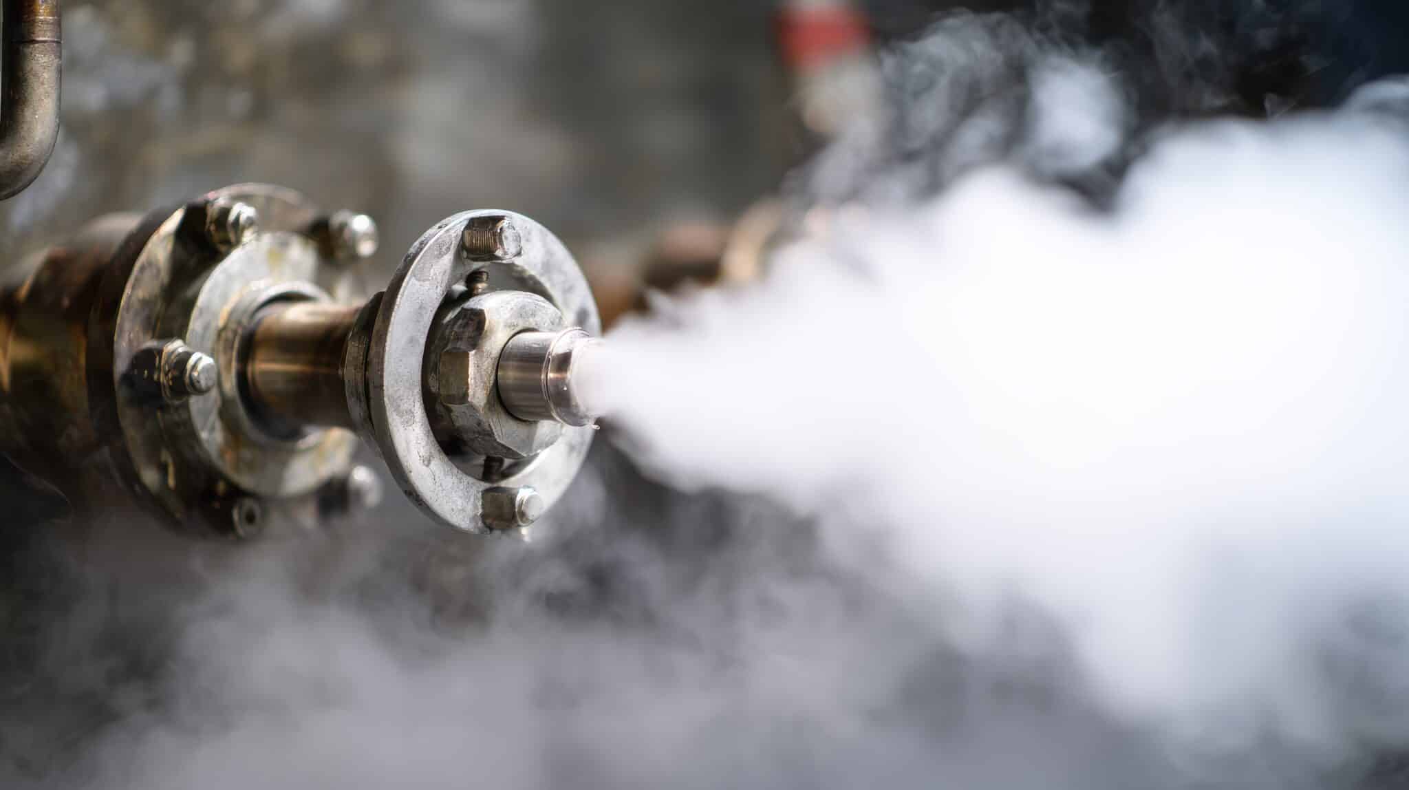 An industrial boiler safety valve releasing high-pressure steam, representing the relief valves used to manage why leadership is so hard.